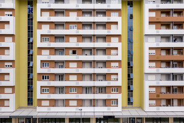 Exterior of a modern high-rise multi-story apartment building - facade, windows and balconies.