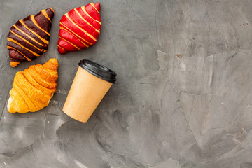Coffee and croissants on dark stone table top view