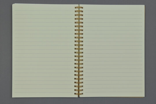 Opened empty notebook on grey background. Top view. Copy space.