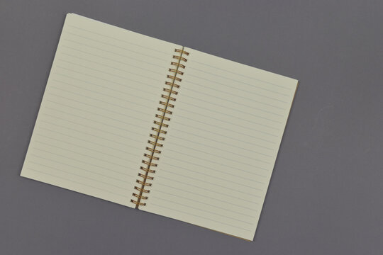Opened empty notebook on grey background. Top view and copy space.
