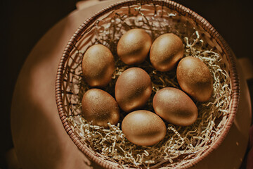 Golden painted eggs in a basket. Easter decor