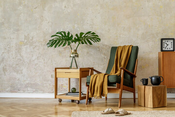 Obraz premium Modern retro composition of living room interior with design armchair, cube, tea pot on the tray, tropical leaf, plaid, carpet, decoration and elegant presonal accessories in wabi sabi concept.