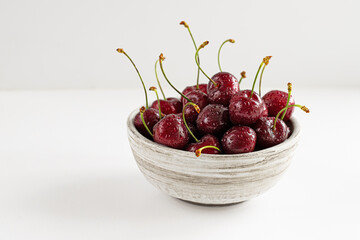 fresh cherry berries with drops in a bowl, closeup, space for text