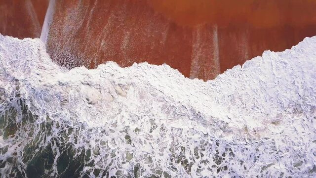 Flying over a sandy beach. Waves break on a sandy beach on the Atlantic coast, aerial View. Nazare, Portugal.