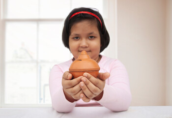 Young girl holding a piggy bank
