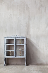 Gray cupboard near plastered wall