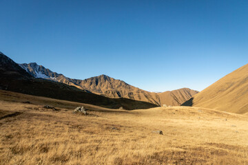 Fototapeta na wymiar dramatic mountain hiking landscape in Juta trekking area landscape in autumn - popular trekking in the Caucasus mountains, Kazbegi region, Georgia.