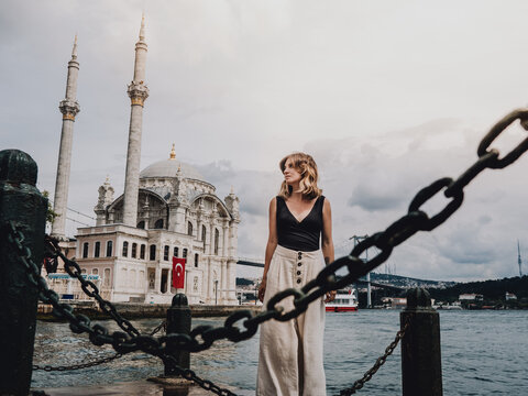 Young woman with the background of a mosque in Istanbul on the bank of the Bosforo River