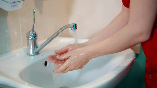 Doctor washing hands at medical clinic. Close up of surgeon washing hands before operating