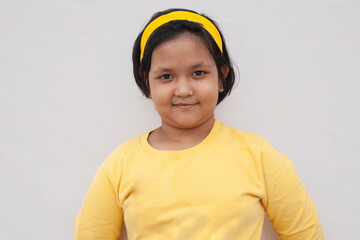 Portrait Of Smiling Girl Standing Against grey Background
