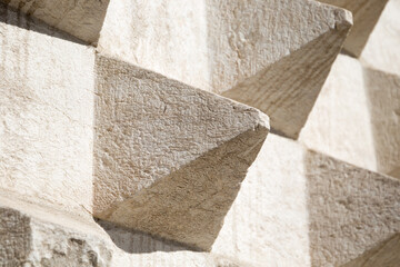 Stone wall texture: white facade consisting of little protruding pyramids. Detail of a modern building in Lisbon Portugal.