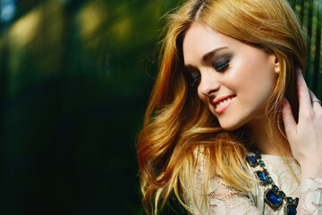 Naklejka premium portrait of a beautiful girl with a smile in the sun