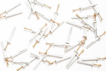 Construction dowels for concrete, stone, and walls are scattered on a white background.