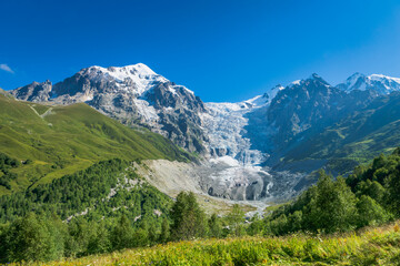 Fototapeta na wymiar Svaneti landscape with glacier and snow-capped mountain in the back near Mestia village in Svaneti region, Georgia.