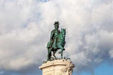 Lisbon Portugal: historical bronze equestrian statue of King Jose I, finished 1775, on Praca do Comercio square. Giant cumulus cloud as a backdrop, on a sunny afternoon.