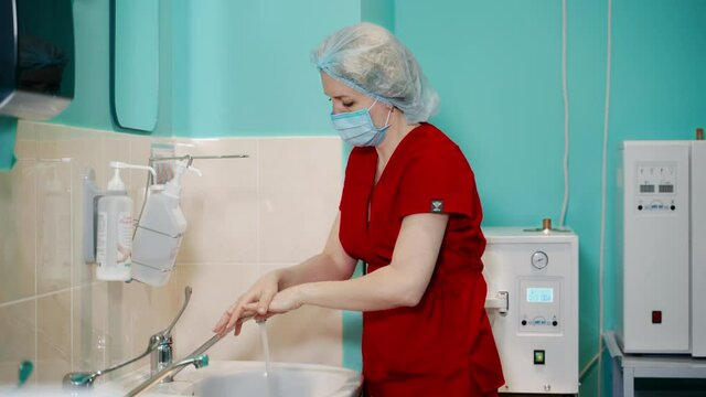Surgeon washing hands to operation. Side view of surgeon scrubbing hands before surgery in hospital