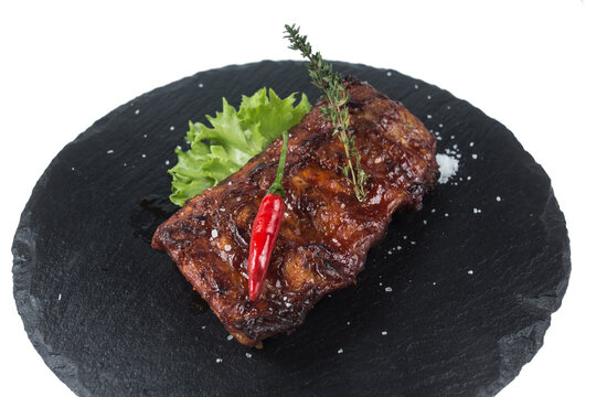 Grilled Meat Steak With Salt, Pepper And Spices On A Black Round Slate Board On A White Background