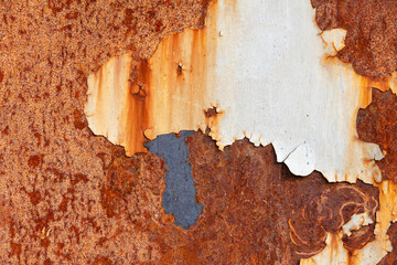 Rust on a metal sheet with peeling white paint