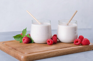 Glass of raspberry milkshake on wooden background