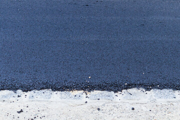 Fresh black asphalt on new street road. Construction at work.