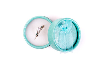 Silver ring with a stone in a turquoise box with a bow isolate on a white background