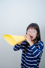 Lettle girl shouting into megaphone with white background.