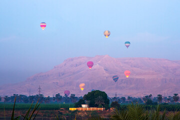 Nile river at sunrise with hot air balloons in Luxor, Egypt.
