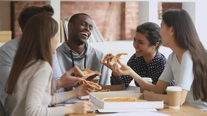 Happy mutiethnic young students or business team people having fun share pizza together in office campus, diverse international staff teen friends talk laugh eat lunch dinner enjoy party sit at table - Powered by Adobe