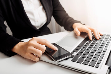 Businessman hands working with finances about cost and calculator and laptop with tablet, smartphone at office in morning light