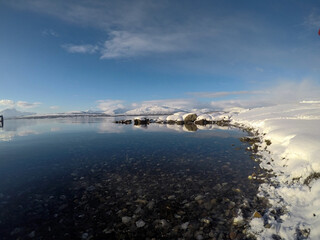deep blue ocean landscape with snowy mountain and sunshine