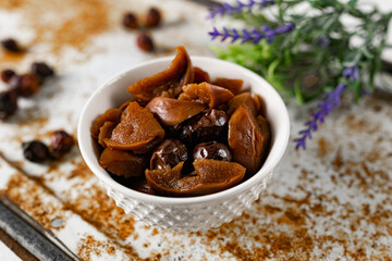 Sweet and soft dried Apple and rose hips prepared for dessert, decorated with a sprig of lavender and dry fruits on an unusual white and rusty metal background