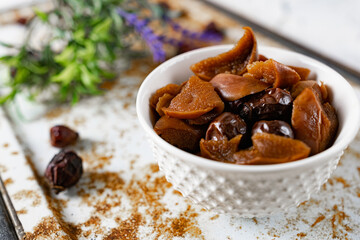 Sweet and soft dried Apple and rose hips prepared for dessert, decorated with a sprig of lavender and dry fruits on an unusual white and rusty metal background