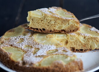 Home cooking.Sponge cake with pineapple on a dark background.