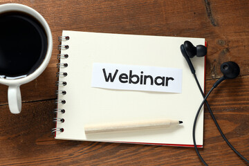 WEBINAR words written in a notebook on a wooden table.
