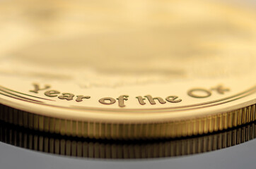 Gold coin with the inscription Year of the Ox. Selective focus.