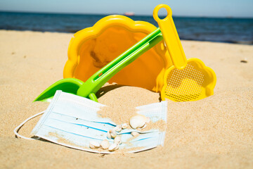 Mask, bucket and spade on the beach (Covid-19)