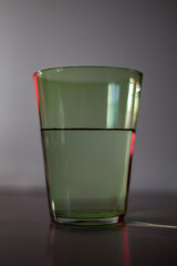 Large green glass with grey background and strong sunlight and glare