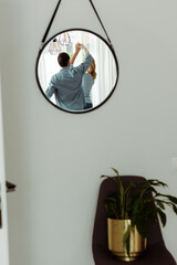 Selective focus of mature couple reflecting in mirror while dancing at home