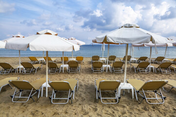 Desert beach with deck chairs and umbrellas waiting for tourists after quarantine. Fantastic white sand, sea and mountain. 2020 summer travel. Relax places island Crete, Greece.