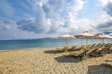 Desert beach with deck chairs and umbrellas waiting for tourists after quarantine. Fantastic white sand, sea and mountain. 2020 summer travel. Relax places island Crete, Greece. Free space for text.