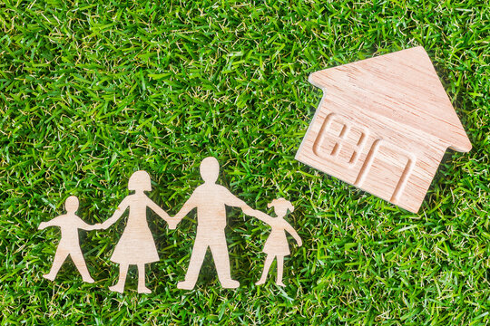 Wood Family Shaped And Home Shaped On Green Grass.  Green Family Concept.