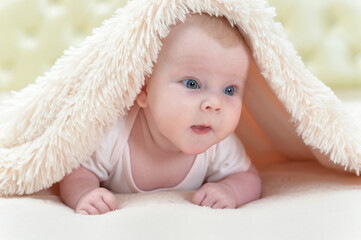 Cute little baby girl playing under the blanket