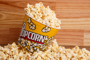 bucket of popcorn on wooden background