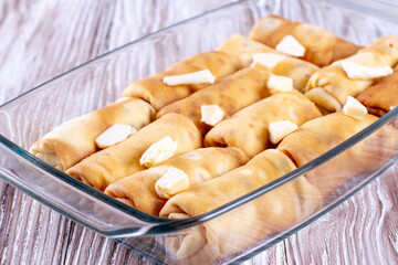 Pancakes with filling in a baking dish. Russian traditional dish. Pancakes with filling