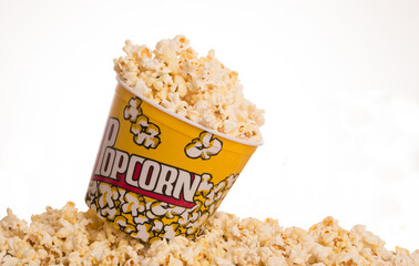 bucket of popcorn on top of a bunch of popcorn on white background