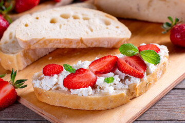 Strawberry sandwiches with cottage cheese and mint on a cutting board