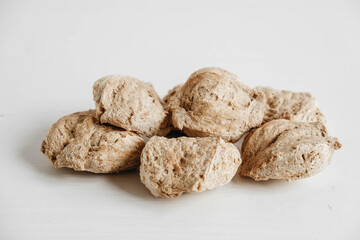 Raw dehydrated soy meat or soya chunks on a white wooden background. Copy, empty space for text