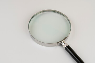 Magnifying glass in a metal frame on a white background close-up