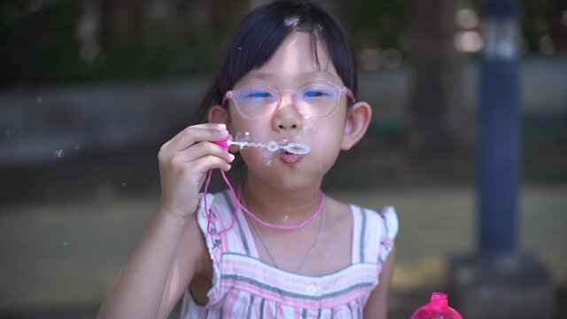 Asian cute girl vintage costume. Blowing bubbles, playing in a field with happiness.