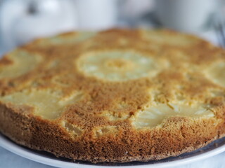 Close up.Confectionery background. Round sponge cake with pineapple on a white wooden table. Healthy natural food.